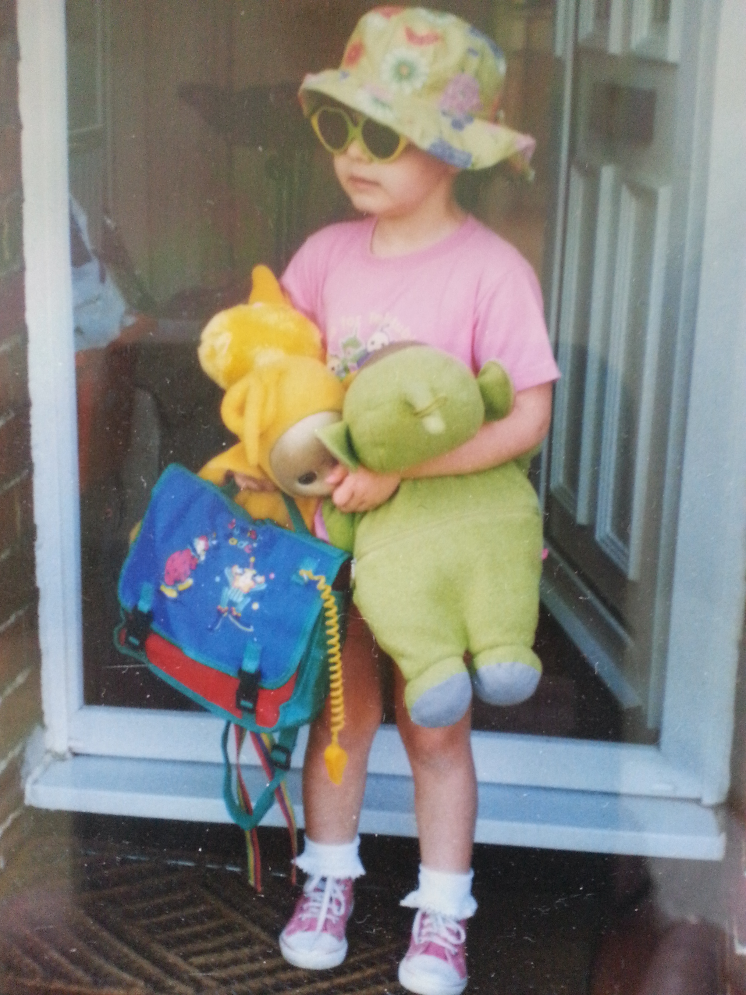 Littel gril dressed up ina sunhat, sunglasses and a satchel ready to go out for the day!