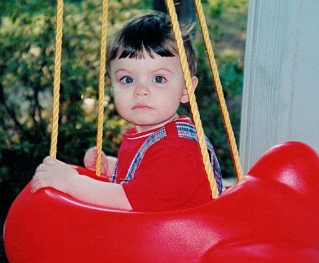 Little girl expressionless on swing